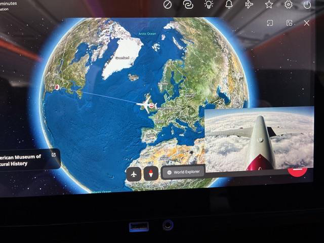 Seatback globe map showing the Atlantic flight route with a live tail-camera view inset.